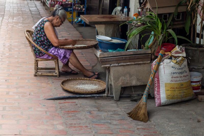 Elderly Lady Sifting Rice